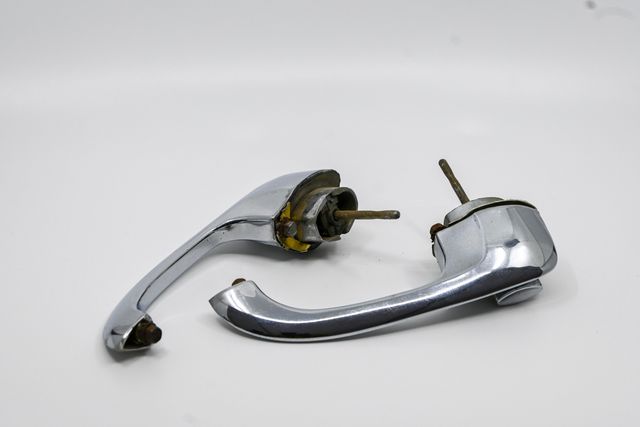 Pair of chrome exterior door handles with corrosion visible on the mounting studs
