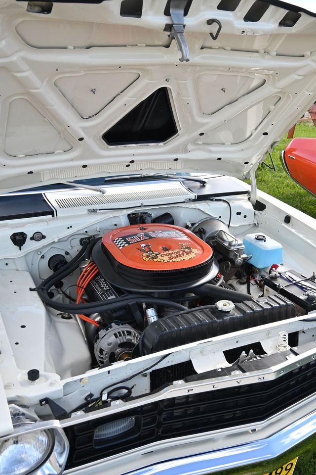 Engine bay of a white Plymouth Duster with a Six Pack air cleaner